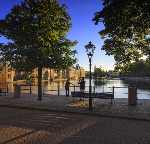 Stel maakt foto tussen de bomen bij de Hofvijver in Den Haag
